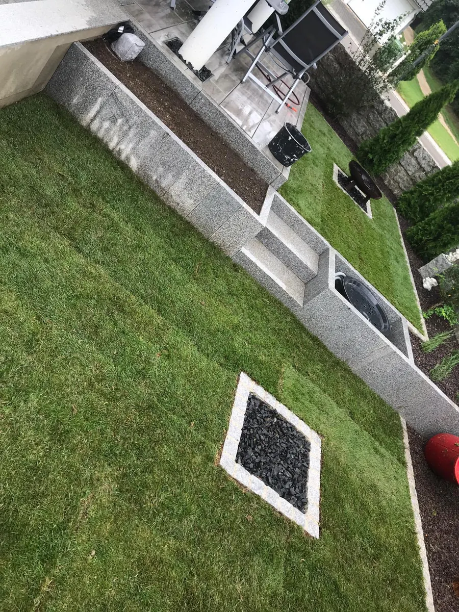 Garten mit Rasenfläche, Mauer und Hochbeet